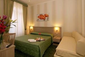 Habitación de hotel con cama verde y sofá en Hotel Argentina, en Roma