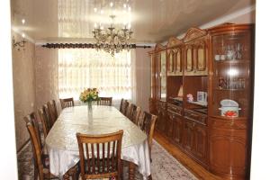 a dining room with a table and chairs and a chandelier at Guest House Jamal in Naryn
