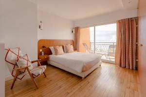 a bedroom with a bed and a balcony at La Perrinière appartement face mer in Royan
