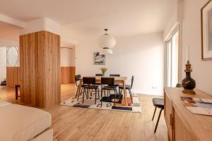 een woonkamer en eetkamer met een tafel en stoelen bij La Perrinière appartement face mer in Royan