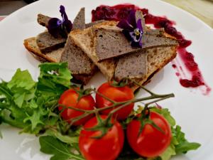 a plate of food with sandwiches and tomatoes at Hotel Alpex in Zabrze