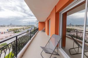 een balkon met 2 stoelen en uitzicht op het strand bij La Perrinière appartement face mer in Royan