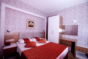 een slaapkamer met een bed met rode kussens en een bureau bij Belport Beach Hotel in Beldibi