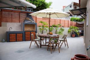 una mesa y sillas con una sombrilla en el patio en Casa Katrine en Lakíthra