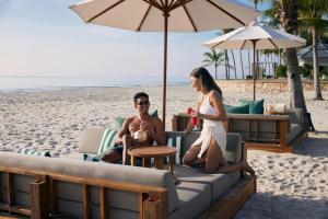 a man and a woman sitting on the beach at Dusit Thani Hua Hin in Cha Am