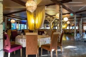 a dining room with tables and chairs and chandeliers at Alpin Resort Apartments Deluxe 2406 in Poiana Brasov