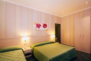 una camera d'albergo con due letti e due lampade di Hotel Argentina a Roma