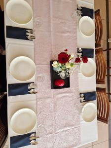 a table with white plates and flowers on a wall at Hotel Alpex View in Zabrze
