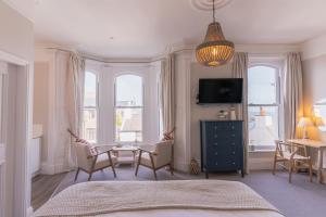 a bedroom with a table and chairs and a tv at Carrick Rooms in Port Saint Mary