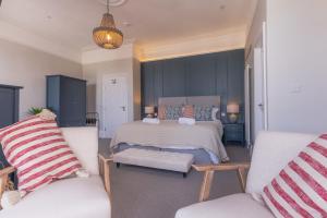 a bedroom with a large bed and two chairs at Carrick Rooms in Port Saint Mary