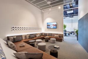 a living room with a couch and tables at H2 Hotel Düsseldorf City in Düsseldorf