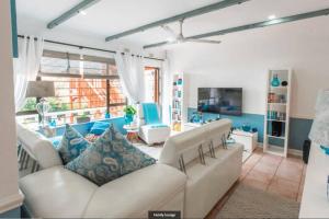 uma sala de estar com um sofá branco e cadeiras em Ariel's Rest Self-catering - 4 Bedroom Luxury Home em Pennington