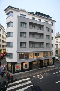 een hoog wit gebouw op de hoek van een straat bij Hotel Simoncini in Luxemburg