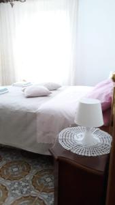 um quarto com uma cama e uma mesa com um candeeiro em Location Serafina Pennapiedimonte em Pennapiedimonte