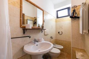 a bathroom with a sink and a toilet and a mirror at Villa Basilio Accommodation in Capo Vaticano