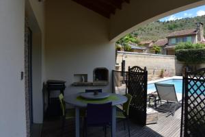 a patio with a table and chairs and a pool at les palmiers des causses in Saint-Rome-de-Tarn