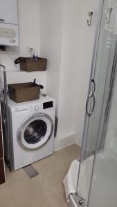a washing machine in a laundry room with a washer at Apartament Mochnackiego in Olsztyn