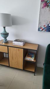 a wooden table with a lamp on top of it at Apartament Mochnackiego in Olsztyn