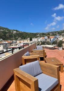 un patio con mesas y sillas en la azotea en B&B Faraglione, en Lipari