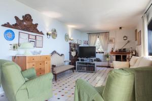 a living room with a couch and a tv at Villa del Golfetto in Plemmirio +14 photos