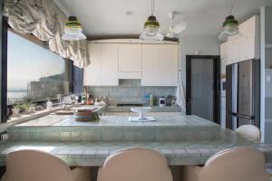 a kitchen with white cabinets and a table with chairs at Villa del Golfetto in Plemmirio