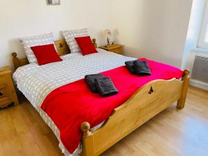 - une chambre avec un grand lit et des oreillers rouges dans l'établissement Appt 50m2, 4 personnes, ménage, draps et serviettes inclus, à Gérardmer