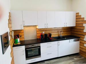 ジェラールメにあるAppt 50m2, 4 personnes, ménage, draps et serviettes inclusの白いキャビネットと黒いカウンタートップを備えたキッチン +7枚の写真