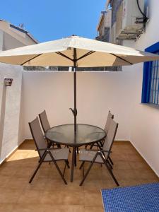 a table and chairs with an umbrella on a patio at Denia Playa III in Denia
