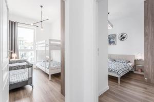 Habitación blanca con 2 camas y espejo. en Chill Apartments Ursynów Premium, en Varsovia