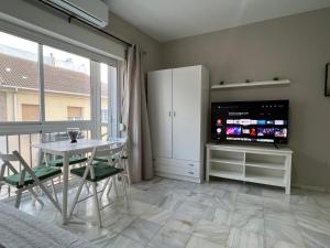 salon z telewizorem, stołem i krzesłami w obiekcie Genuar Apartments Malaga Center 2 w Maladze +7 zdjęć