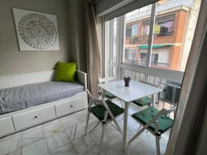 niewielka sypialnia ze stołem, łóżkiem i oknem w obiekcie Genuar Apartments Malaga Center 2 w Maladze
