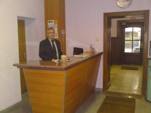 a man sitting at a counter in a room at Hotel Zentrum in Hannover