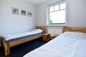 a bedroom with two beds and a window at GODS06006-FeWo 'Luv un Lee' in Gollendorf