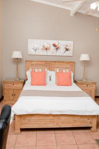 a bedroom with a large bed with orange pillows at 85 Ehmke Guesthouse in Nelspruit