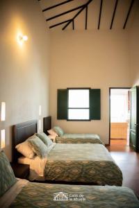 a bedroom with two beds and a window at Hotel Campestre Casa de la Abuela in La Capilla