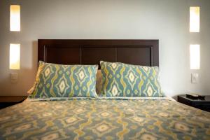 a bed in a hotel room with two pillows at Hotel Campestre Casa de la Abuela in La Capilla