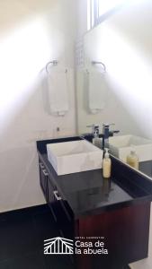 a bathroom with a white sink and a mirror at Hotel Campestre Casa de la Abuela in La Capilla