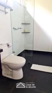 a bathroom with a toilet and a glass shower at Hotel Campestre Casa de la Abuela in La Capilla