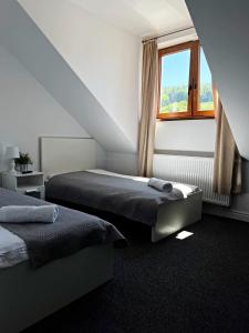 a bedroom with two beds and a window at Gospoda Magurska in Sękowa