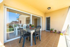 patio con mesa y sillas en el balcón en Hauzify I Apartament Cala Pepo, en L'Ametlla de Mar