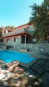 una casa con piscina frente a ella en Villa Los Almendros Rural, en El Padul