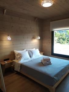 ein Schlafzimmer mit einem großen Bett an einer Holzwand in der Unterkunft Ktima Vlastou vacation houses in Vourvourou