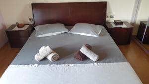 1 cama con 2 toallas y 2 almohadas en Wonderful Spot to Recharge, en Kalamata