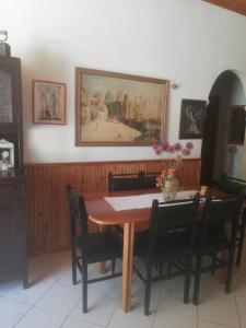 a dining room table with chairs and a painting on the wall at Atlantis Hotel in Skala Potamias