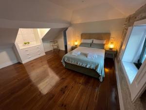 a bedroom with a bed and a wooden floor at A Portuguesa Guest House in Porto