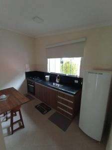 a small kitchen with a sink and a refrigerator at Marina Estância Confiança in Bragança Paulista