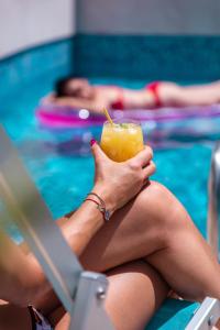 a woman sitting in a pool holding a drink at Villa Katarina in Budva