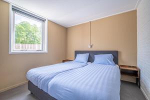 a bedroom with a large bed with a window at Zeester in Serooskerke