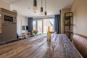 a bottle of wine on a wooden table in a living room at Zeester in Serooskerke