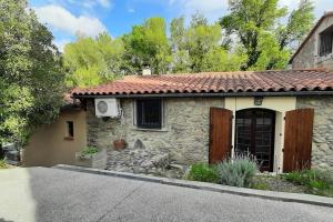 une maison en pierre avec un toit rouge et une allée. dans l'établissement Gîte de charme dans Mas Catalan, à Prades